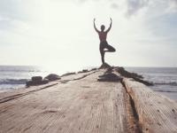 Frau macht Yoga am Meer