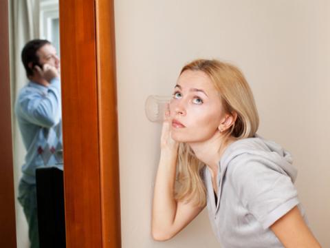 Frau hört heimlich ihrem Mann beim Telefonieren zu.