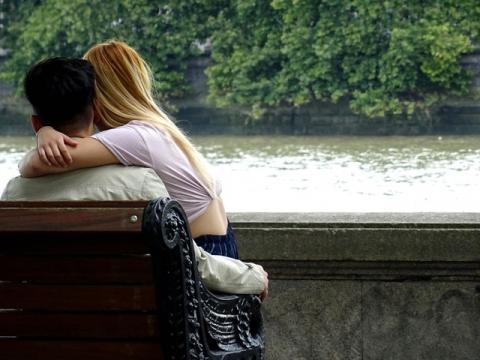 girl and boy hugging on bench